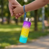 A 300 ml-es motivációs kulacs lóg egy kislány csuklóján, aki édesanyja kezét fogja séta közben