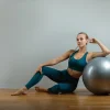 Egy fiatal nő tornázik a fitness labdával