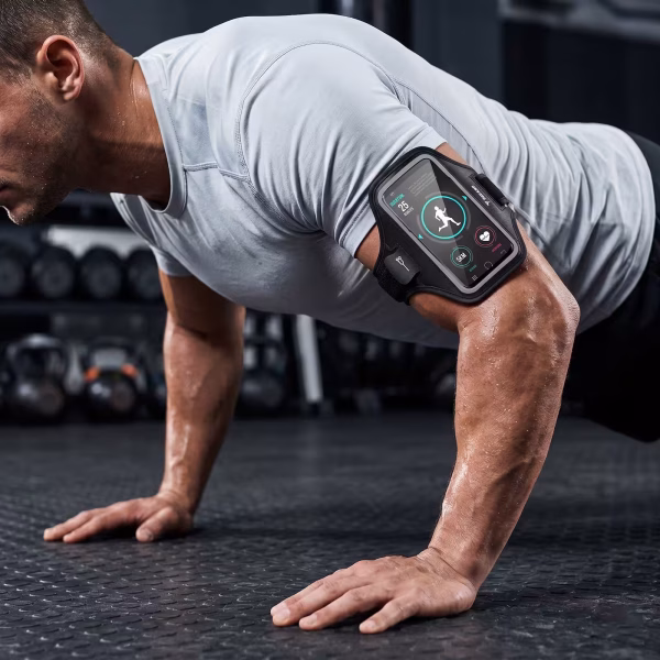 Egy fehér pólót és karpántos telefontokot viselő férfi fekvőtámaszt nyom egy edzőteremben