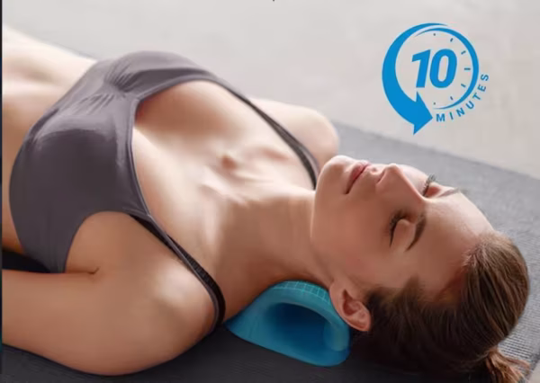 Egy edzőmatracon fekvő nő, aki a nyaknyújtó párnát használja a napi 10 perces relaxációjához
